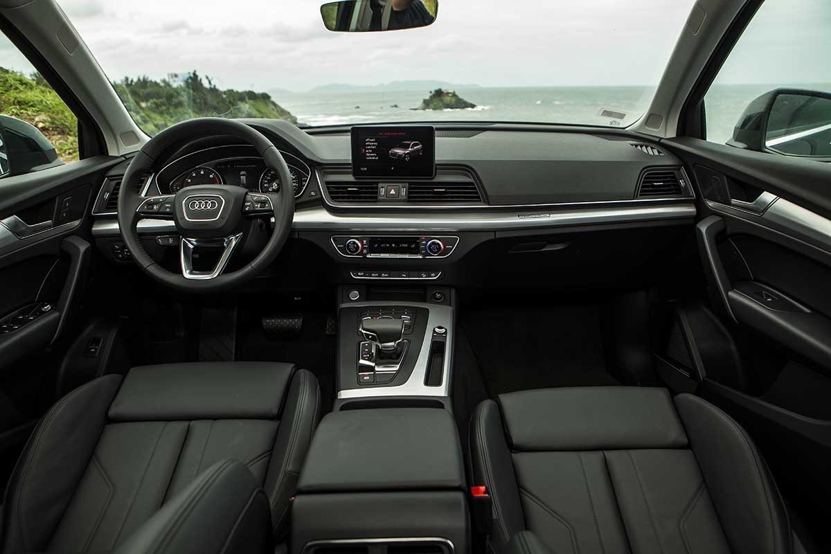 Vào bên trong xe, điểm nhấn đầu tiên là thiết kế kiểu “vòng cung” từ thành cửa đến bảng táp-lô tạo cảm giác rộng rãi và thoải mái. Bảng đồng hồ trên Audi Q5 mới có thiết kế như đồng hồ cơ học với màn hiển thị màu thông tin 7 inch ở giữa. Hai chế độ hiển thị có thể chuyển bằng nút “View” trên vô-lăng đa chức năng.  