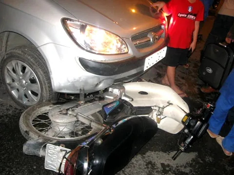 Xe máy chui dưới gầm taxi